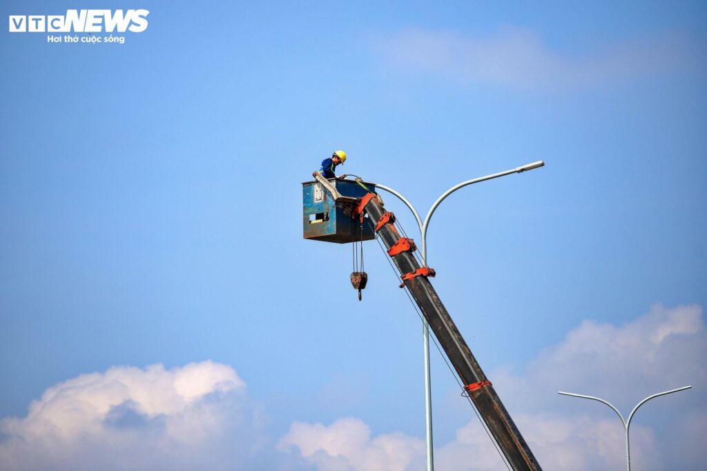 Trên công trường, công nhân đang thi công hệ thống đèn chiếu sáng, biển báo giao thông, vạch kẻ đường, phân làn cũng đã được lắp đặt.